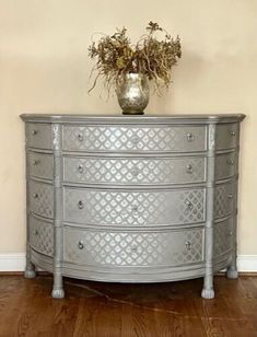 a silver dresser with flowers on top of it