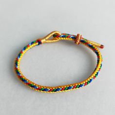 a yellow and blue rope bracelet with gold clasp