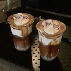 two glasses of iced coffee sitting on top of a counter