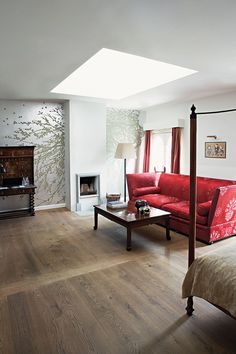 a living room with a red couch and wooden floors