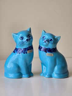 two blue ceramic cats sitting next to each other