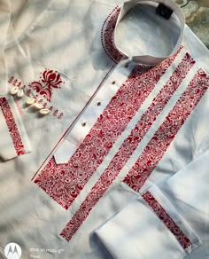 a white shirt with red and white designs on it