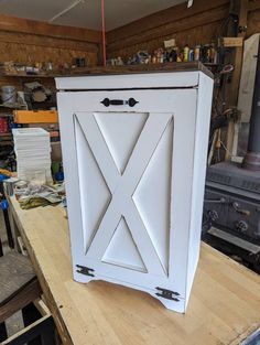 a white cabinet sitting on top of a wooden table