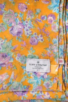 a yellow floral shirt with purple and blue flowers on it