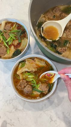 two bowls of soup with meat, vegetables and noodles being spooned into one bowl