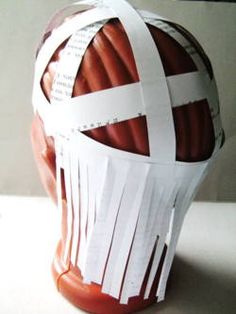 a paper mache helmet with white strips on it