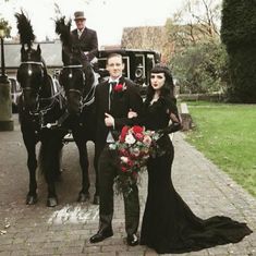 a man and woman are standing in front of two horse drawn carriages with flowers on them