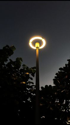 a street light that is lit up in the night sky with no one around it