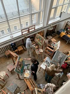 an overhead view of people painting in a room with large windows and floor to ceiling windows