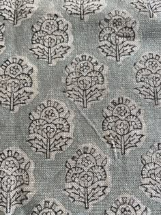 an upholstered fabric with trees and leaves on the side, in grey tones