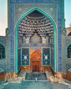 the entrance to an ornate building with blue and green tiles on it's walls