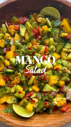 mango salad in a wooden bowl with lime wedges