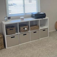 a room with several storage bins and a printer on the shelf next to it