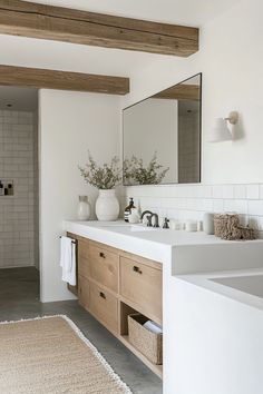 a white bathroom with two sinks and mirrors