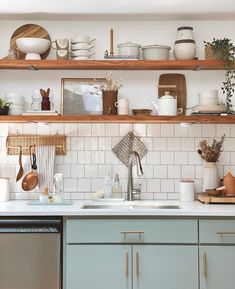 the shelves above the kitchen sink are filled with dishes