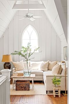 a living room filled with furniture and a window in the wall next to a wooden floor