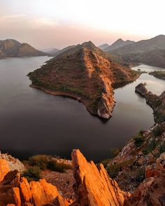 an island in the middle of a lake surrounded by mountains