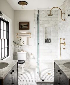 a bathroom with black and white flooring and marble counter tops on the shower wall