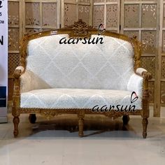 a white couch sitting on top of a tiled floor next to a wooden framed wall