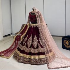 a woman in a maroon and gold wedding gown