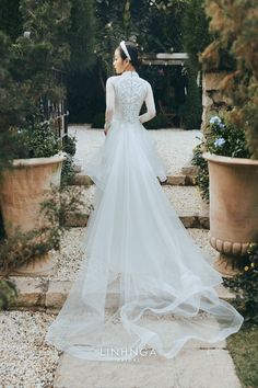 a woman in a wedding dress is standing outside