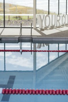 an empty swimming pool with the words your club on it's wall and red rope