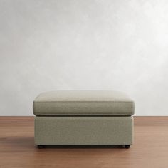 a footstool sitting on top of a wooden floor next to a white wall