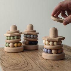 a person is playing with wooden beads on a table and stacking them up together