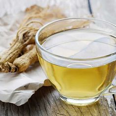 a glass cup filled with green tea next to a wooden table