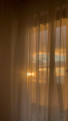 the sun is shining through sheer curtains