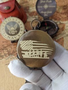 a pocket watch with an american flag on it and two other items in the background