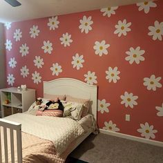 a child's bedroom decorated in pink and white with daisies on the wall