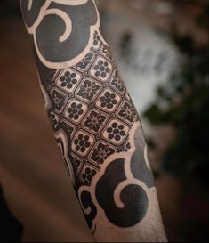 a man's arm with an intricate tattoo design on the left forearm and shoulder