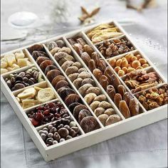 a tray filled with lots of different types of donuts and other treats on top of a table