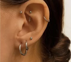 a close up of a person wearing an ear with two piercings on their ears