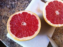 two grapefruits cut in half on a cutting board