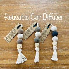 three bracelets with tasselled beads and two tags on them that say reusable car diffuser