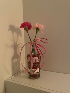 a bottle with flowers in it sitting on a shelf