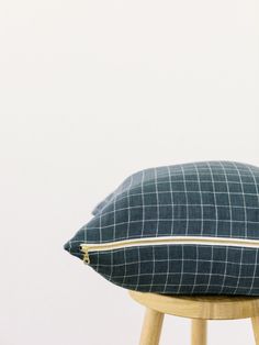 a blue and white pillow sitting on top of a wooden stool