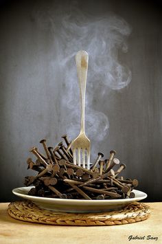 a white plate topped with lots of chocolate sticks and a fork sticking out of it