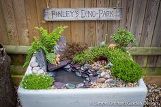 an outdoor pond with rocks and plants in it next to a wooden sign that says fenley's dine - park