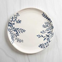 a white plate with blue leaves on it