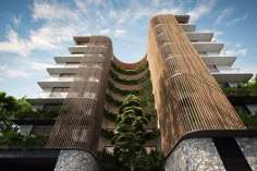 two tall buildings with plants growing on the sides and balconies at the top