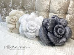 three different types of fabric flowers on a couch