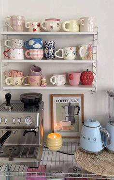 a shelf filled with lots of coffee cups and mugs next to a toaster