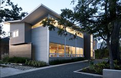 a modern house is lit up by the light coming from the windows on the building