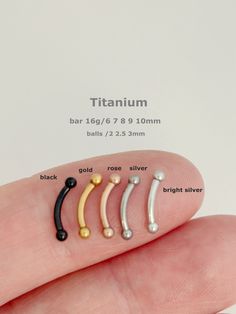 a finger with five different colored nose rings on it's thumb and the size of each one