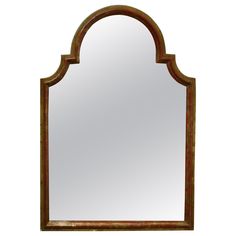 a large mirror with an arched frame and wood trimmings on the bottom half