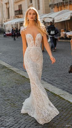 a woman is walking down the street in a white wedding dress with an open back