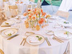 the table is set with place settings and flowers